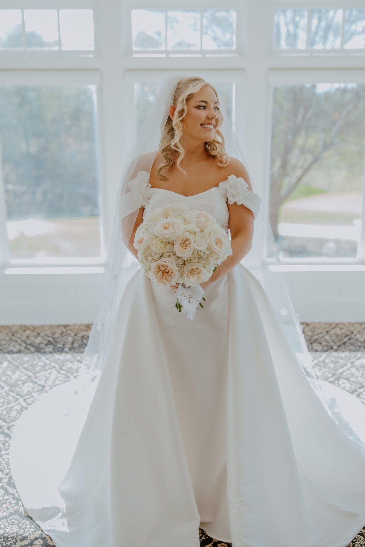 Bride with bouquet by the window